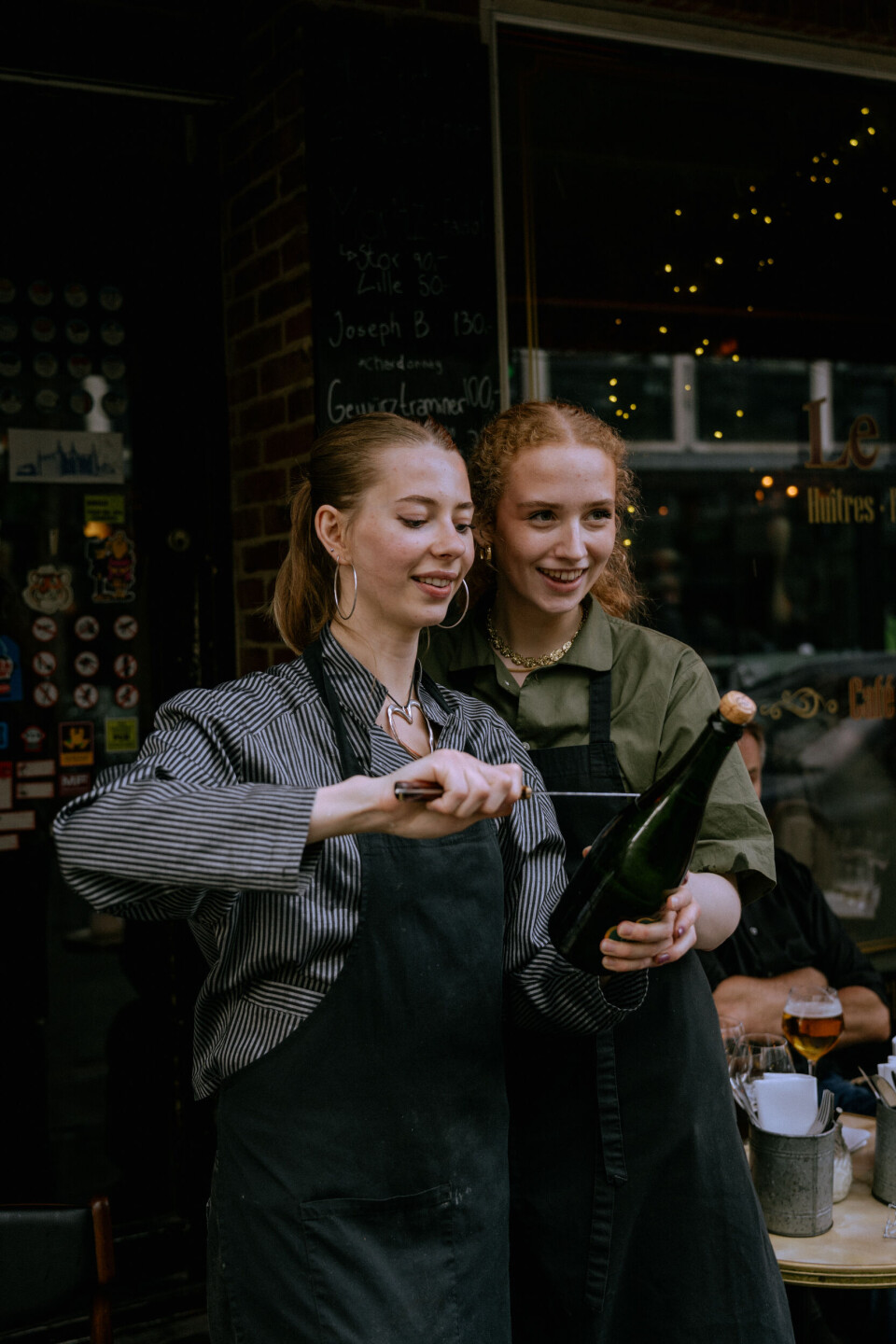Personalet på Klassisk Bistro 65 sabler en flaske champagne ude på gaden