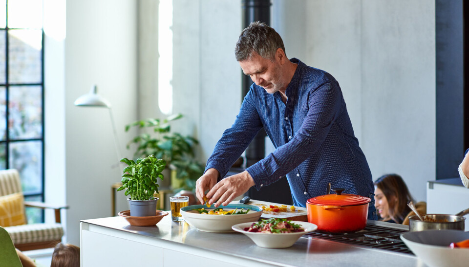 Man in his 50s dressing salad at home, making lunch, enjoyment, healthy lifestyles
