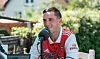 Christian Hebo i Arsenal-trøje taler i mikrofon ved udendørs bord.