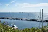 Havudsigt over Øresund. Forrest i billedet er en havnekaj med syv sejlbåde og en motorbåd.